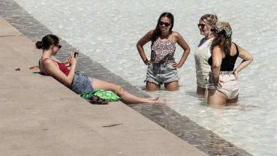 Unas jóvenes se refrescan en una fuente este lunes en la ciudad de Valencia.
