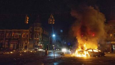 Un coche arde en la intersección de la calle norte con la calle Monroe durante los disturbios provocados durante una protesta contra la muerte de Freddie Gray en Baltimore. EFE