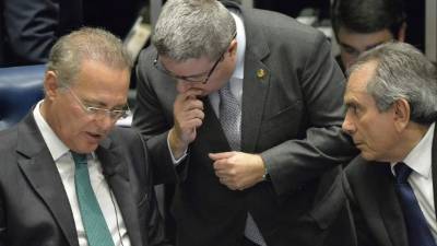 El presidente del Senado Renan Calheiros (i) y los senadores Antonio Anastasia (c) y Raimundo Lira (d) conversan durante el debate en contra de la presidenta Dilma Rousseff.