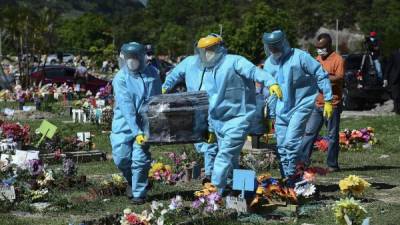 Entre las víctimas más destacadas que fallecieron en junio por causa de la covid-19, estuvo el periodista Carlos Riedel, cuyos restos (foto) son llevados por los empleados del cementerio a su lugar descanso final.