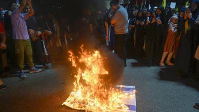 Simpatizantes de Hezbollah queman una bandera israelí durante una celebración de los ataques que el grupo militante Hamás llevó a cabo contra Israel.