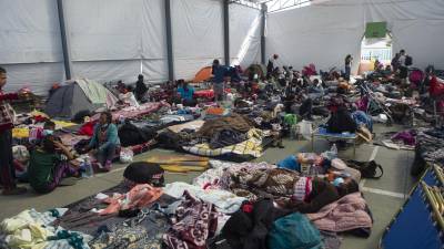 Cientos de migrantes descansan en un precario albergue habilitado en la Ciudad de México tras la llegada de la caravana.