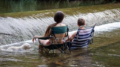 Unos jóvenes se refrescan en el río Iregua a su paso por Logroño.