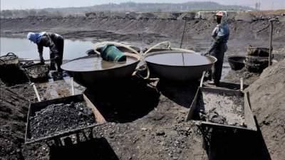 Trabajadores migrantes de las provincias chinas de Shandong, Hubei y Heilongjiang, entre otras, trabajan en una mina de carbón a cielo abierto en Shenyang, al noreste de China. EFE/Archivo