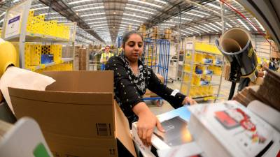 Una empleada de Amazon en Inglaterra realiza labores de empaque. De acuerdo a la UE, el desempleo en la eurozona a octubre se ubicó en 12.1%. / AFP