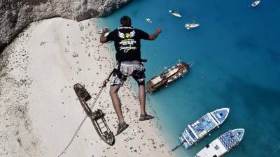 Lukas Michul, un miembro de 'los caminadores de ensueño' salta desde un precipicio sobre las aguas de la playa Navagio en Grecia.