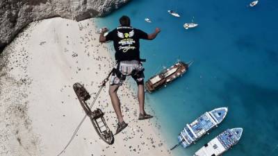 Lukas Michul, un miembro de 'los caminadores de ensueño' salta desde un precipicio sobre las aguas de la playa Navagio en Grecia.