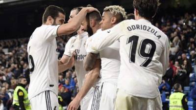 Real Madrid's French forward Karim Benzema (C) celebrates with teammates after scoring his team's third goal during the Spanish League football match between Real Madrid CF and SD Huesca at the Santiago Bernabeu stadium in Madrid on March 31, 2019. (Photo by JAVIER SORIANO / AFP)