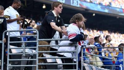 Geordie Brower, fanático de los Saints de Nueva Orleans, ayuda a un joven discapacitado fanático de los Giants de Nueva York.Foto/Twitter