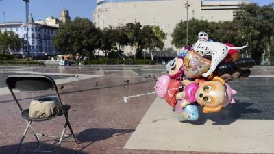 A man places a candle on a paper that reads 'Catalunya - place of peace' in Las Ramblas, Barcelona, Spain, Friday, Aug. 18, 2017. Spanish police on Friday shot and killed five people carrying bomb belts who were connected to the Barcelona van attack that killed at least 13, as the manhunt intensified for the perpetrators of Europe's latest rampage claimed by the Islamic State group. (AP Photo/Manu Fernandez)