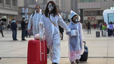 Dos personas se protegen del contagio de coronavirus en China. Foto: AFP