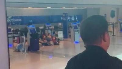 Un grupo de personas se tira al suelo tras escuchar disparos en el aeropuerto Love Field de Dallas.