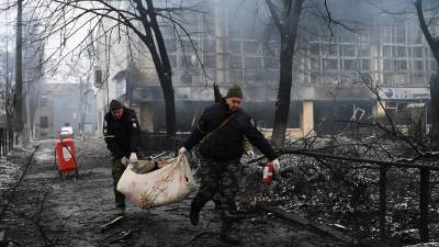 Rescatistas retiran el cuerpo de un civil fallecido durante uno de los bombardeos a la capital ucraniana.