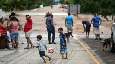 People shelter in a highway from the Ulua river overflowed due to the heavy rains caused by Hurricane Eta, now degraded to a tropical storm, in El Progreso, department of Yoro, 260 kms north of Tegucigalpa, on November 5, 2020. (Photo by Orlando SIERRA / AFP)