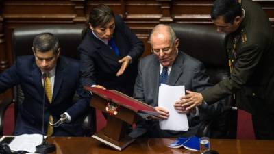 Peruvian President Pedro Pablo Kuczynski (2-R) is pictured next to the President of the Congress Luis Galarreta (L) after delivering a speech before the Peruvian National Congress in Lima, while the opposition, demands he steps down or face impeachment over graft allegations linked to Brazilian construction giant Odebrecht, on December 21, 2017. If Peru's Congress sets the impeachment process in motion it would make Kuczynski the highest-profile political figure to be punished in the expanding scandal surrounding Odebrecht, a Brazilian engineering and construction firm that admitted to paying millions of dollars in bribes in several Latin American countries to secure public works contracts. / AFP PHOTO / ERNESTO BENAVIDES