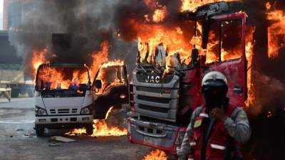 Vehículos arden en llamas tras las protestas que tuvieron lugar este día en Caracas contra el gobierno de Nicolás Maduro.