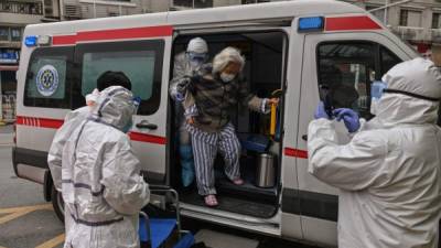 Personal médico traslada a una paciente con coronavirus en Wuhan. Fotos: AFP