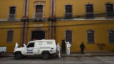 Criminal Investigation agents and forensic personnel wearing protective equipment arrive at the San Felipe Hospital, where a COVID-19 patient was allegedly strangled in Tegucigalpa, on May 29, 2020. - 196 people have died in Honduras from a total of 4,752 confirmed cases of the new coronavirus. (Photo by ORLANDO SIERRA / AFP)