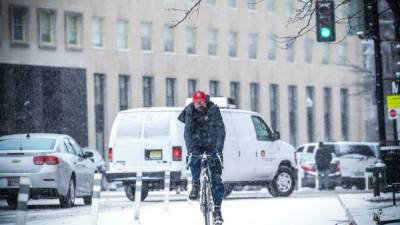 Un hombre monta su bicicleta mientras cae nieve en Washington. Foto: AFP
