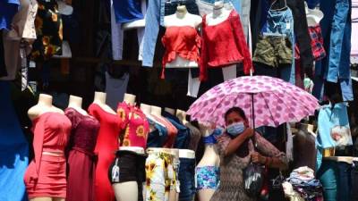 A woman wears a face mask during the COVID-19 pandemic, at a street market in Tegucigalpa on June 8, 2020, after the governmet announced the resumption of economic activity. - Honduras reopens its business activities, cautiously, after almost three months of confinement, though, according to experts, at the worst time to do so due to the rapid rise of the coronavirus and at high risk of closing again. (Photo by ORLANDO SIERRA / AFP)