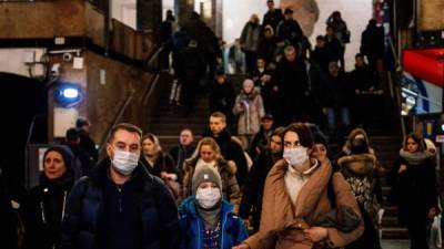 Una familia con una máscara facial caminando hoy en la estación de metro Biblioteka Imeni Lenina en Moscú.
