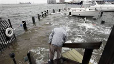 Norfolk resident Jack Devnew looks at the water covering a dock as he checks on his boat at a marina near downtown Norfolk, Va., Monday, Oct. 29, 2012. Rain and wind from Hurricane Sandy are hitting the area. (AP Photo/Steve Helber)