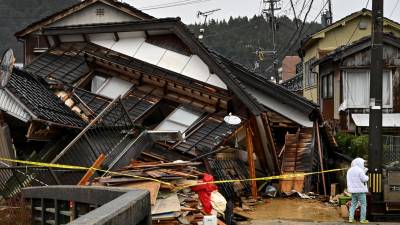 Rescatistas trabajan bajo la lluvia en busca de las personas atrapadas bajo escombros.