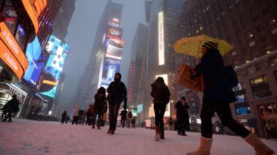 Neoyorquinos caminan por Times Square cubierto de nieve.