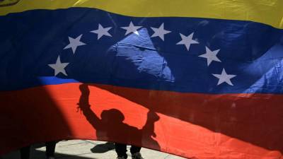 Los opositores del presidente venezolano Nicolás Maduro exhiben una bandera venezolana frente a la sede de las Naciones Unidas en Caracas.