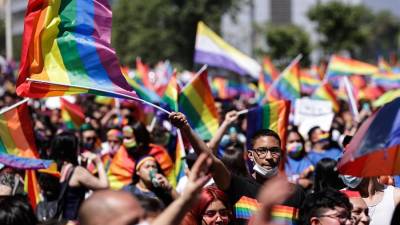 Personas mientras participan en la Marcha del Orgullo en apoyo a la comunidad LGTBI del país, por las calles de Santiago.