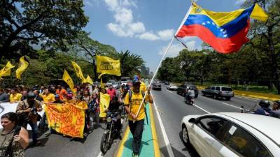 Venezuelan opposition activists chanting slogans march in protest against the government of President Nicolas Maduro in front of the Ombudsman's office in Caracas on April 3, 2017. The Organization of American States (OAS) will ponder Monday if it declares Venezuela in violation of its constitutional order under the Inter-American Democratic Charter and activates mechanisms to pressure the country to call elections and release prisoners. / AFP PHOTO / FEDERICO PARRA