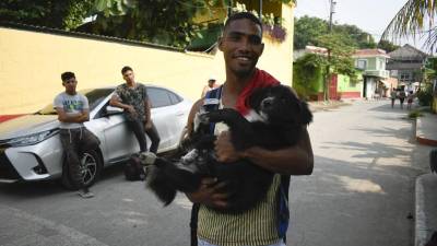 El migrante venezolano Gilberto Rodríguez posa con su perro llamado Negro afuera de la Casa del Migrante en Tecun Uman