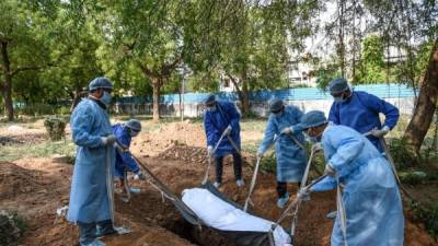 Voluntarios sepultan a una víctima de coronavirus en un cementerio de Nueva Delhi, India./AFP.