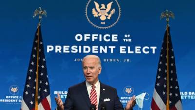 US President-elect Joe Biden shows a face mask as he answers questions about COVID 19 from the press at The Queen in Wilmington, Delaware on November 16, 2020. - US President-elect Joe Biden expressed frustration on November 16, 2020 about Donald Trump's refusal so far to cooperate on the White House transition process, saying 'more people may die' without immediate coordination on fighting the coronavirus pandemic. (Photo by ROBERTO SCHMIDT / AFP)