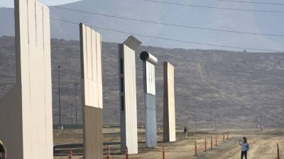Una mujer toma fotografías frente a uno de los prototipos del muro fronterizo entre EEUU y México. EFE/Archivo