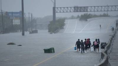 Los residentes de la evacuación del área de Meyerland caminan sobre un viaducto I-610 para la ayuda adicional durante las consecuencias del huracán Harvey.