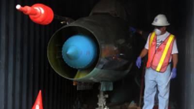 A man works in a container with the MIG-21 jets found inside the North Korean Chong Chon Gang vessel where an alleged Soviet-built radar control system for surface-to-air missiles was found, at the Manzanillo Port in Colon, 90 km from Panama City, on July 21, 2013. UN sanctions experts will go to Panama soon to investigate a North Korean ship that was intercepted carrying weapons, a US diplomat said Thursday. The vessel set out from Cuba and was trying to enter the Panama Canal when it was stopped by an anti-narcotics patrol, which later found the weapons concealed beneath several tonnes of sugar. AFP PHOTO / Rodrigo ARANGUA