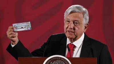 El presidente de México, Andrés Manuel López Obrador, muestra su boleto para la rifa del avión presidencial durante su rueda de prensa diaria este martes, en el Palacio nacional de Ciudad de México (México). EFE/ José Méndez