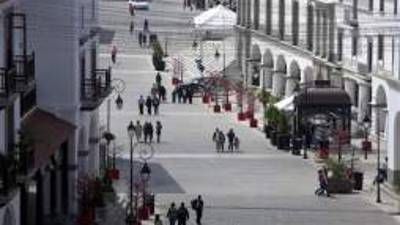 In this Nov. 25, 2012 photo, visitors walk in Paseo Cayala, a nearly independent city on the edges of Guatemala City. Cayala's backers promote the development as a safe haven in a troubled country, one with an unusual degree of autonomy from the chaotic capital. It also embraces a school of urban planning that advocates a return to a traditional concept of a city, with compact, agreeable spaces where homes and shops are intermixed. (AP Photo/Moises Castillo)