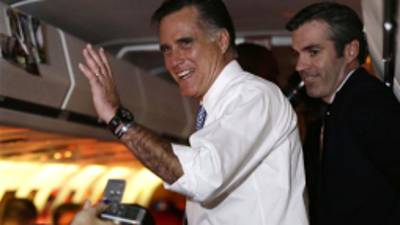 Republican presidential candidate and former Massachusetts Gov. Mitt Romney waves to reporters after he took questions on his campaign plane en route from Pittsburgh to Boston, Tuesday, Nov. 6, 2012. At right is senior adviser Kevin Madden. (AP Photo/Charles Dharapak)