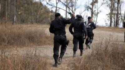 A policeman practices lassoing in anticipation of roping a stray dog, as he and fellow officers search for strays in a park on the hilltop borough of Iztapalapa in southeast Mexico City. Tuesday, Jan. 8, 2013. The fatal mauling of four people by feral dogs in a Mexico City park set off debate Tuesday about the city's love/hate relationship with its dog population, and the guilt or innocence of 25 dogs trapped near the scene of the nightmarish killings. (AP Photo/Eduardo Verdugo)
