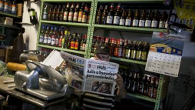 CAR01. CARACAS (VENEZUELA), 11/07/13.- Un hombre lee un periódico con titular sobre la noticia del caso Snowden hoy, jueves 11 de julio de 2013, en un abasto de Caracas (Venezuela). El excontratista de la CIA recibió una oferta de asilo de Venezuela, pero el martes el canciller venezolano, Elías Jaua, dijo que Snowden aún no había ratificado su intención de refugiarse en el país. EFE/MIGUEL GUTIÈRREZ