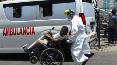 A health worker from the Without Borders Medical organization transports a Covid-19 infected man to the triage centre in colonia Mayangle in Tegucigalpa, on July 8, 20021. (Photo by Orlando SIERRA / AFP)