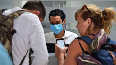 An airline employee wears a protective face mask as a precaution against the spread of the new Coronavirus, COVID-19, at Toncontin International Airport, in Tegucigalpa, on March 6, 2020. - Honduran Government has intensified the security on the borders and airports to prevent an eventual propagation of the new Coronavirus, COVID-19. (Photo by ORLANDO SIERRA / AFP)