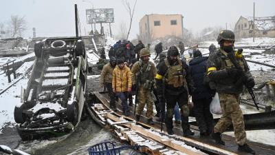 Soldados ucranianos resguardan a los civiles que intentan evacuar la capital Kiev.