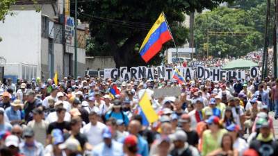 Opposition activists march during a protest against President Nicolas Maduro's government, in Caracas on May 31, 2017.Venezuelan authorities on Wednesday began signing up candidates for a planned constitutional reform body, a move that has inflamed deadly unrest stemming from anti-government protests. Opponents of socialist President Nicolas Maduro say he aims to keep himself in power by stacking the planned 'constituent assembly' with his allies. / AFP PHOTO / FEDERICO PARRA