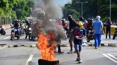 Demonstrators block an avenue during an anti-government protest in Caracas, on July 20, 2017.A 24-hour nationwide strike got underway in Venezuela Thursday, in a bid by the opposition to increase pressure on beleaguered leftist President Nicolas Maduro following four months of deadly street demonstrations. / AFP PHOTO / RONALDO SCHEMIDT