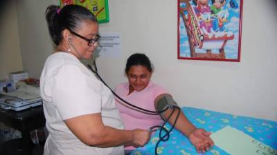 Una enfermera le mide la presión arterial a una paciente en la clínica del barrio Barandillas.