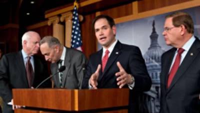 Sen. Marco Rubio, R-Fla.. center, answers a reporter's question as he and a bipartisan group of leading senators announce that they have reached agreement on the principles of sweeping legislation to rewrite the nation's immigration laws, during a news conference at the Capitol in Washington, Monday, Jan. 28, 2013. From left are Sen. John McCain, R-Ariz., Sen. Charles Schumer, D-N.Y., Sen. Marco Rubio, R-Fla., and Sen. Robert Menendez, D-N.J. The deal covers border security, guest workers and employer verification, as well as a path to citizenship for the 11 million illegal immigrants already in this country. (AP Photo/J. Scott Applewhite)