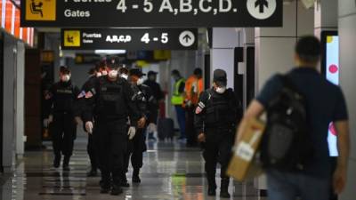 La policía salvadoreña vigila el aeropuerto de El Salvador para impedir el ingreso de extranjeros sin previa cuarentena./AFP.